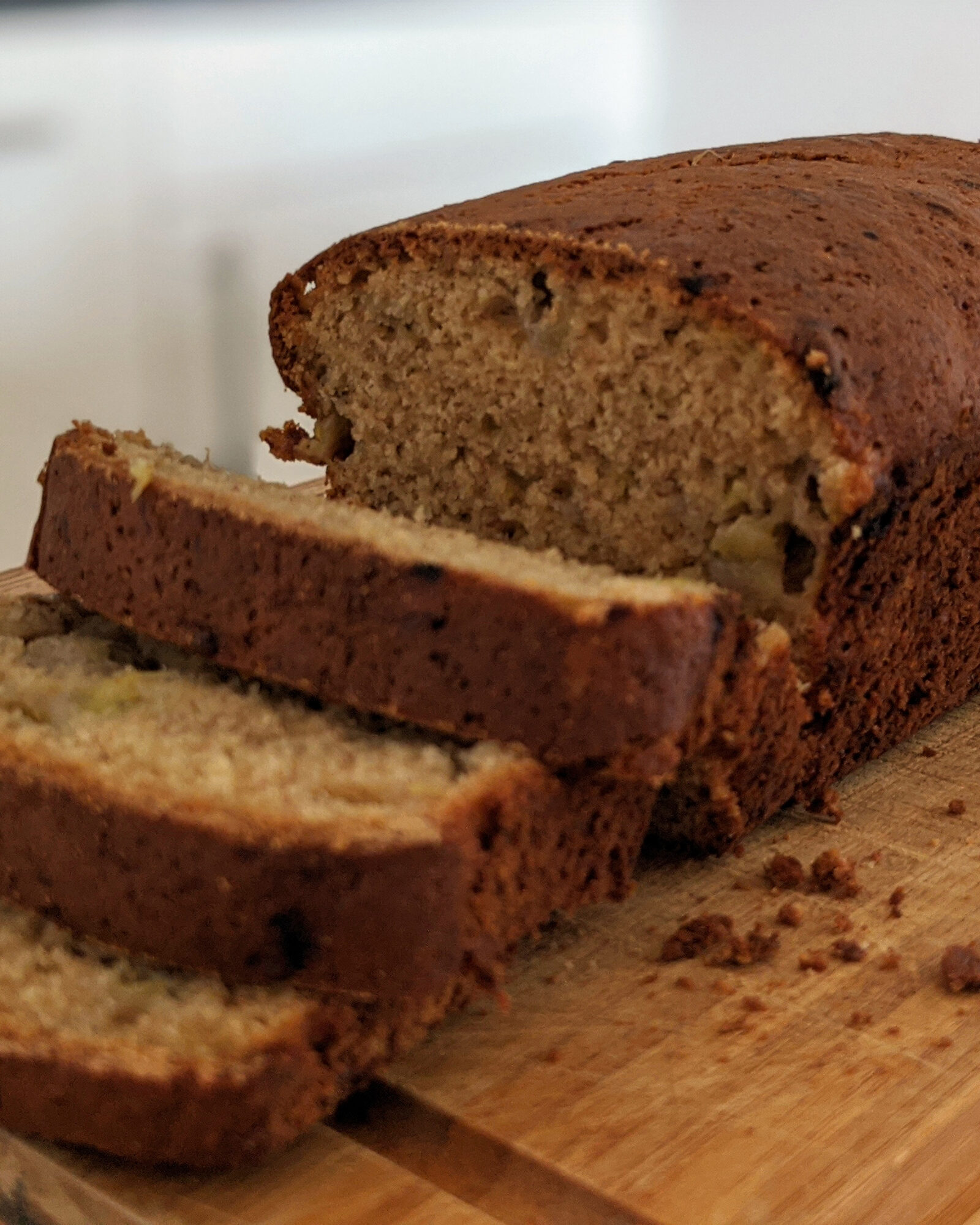 A close-up of sliced banana bread on a cutting board.