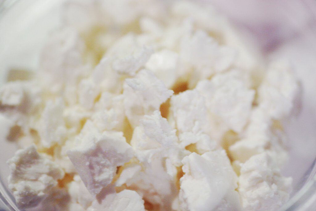 A close-up bowl of crumbled feta cheese.
