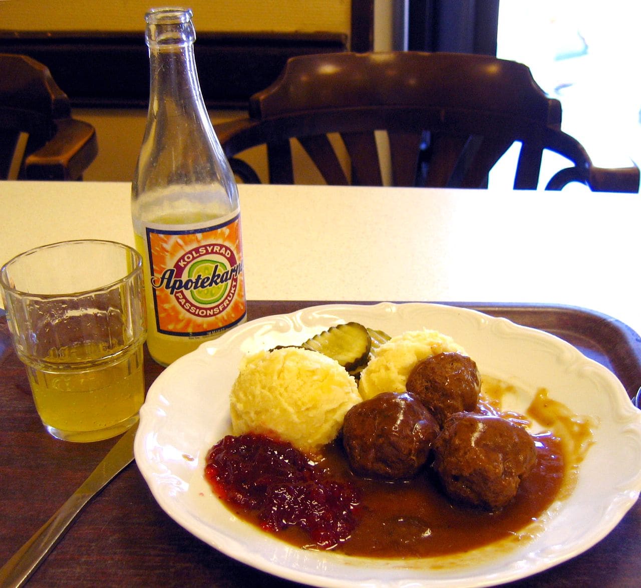 Swedish meatballs with lingonberries and mashed potatoes on a restaurant plate.