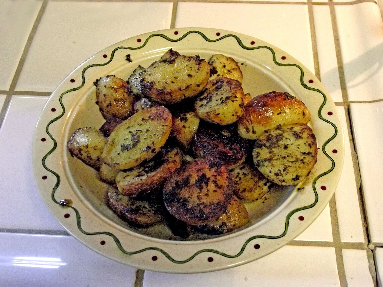 Boiled potatoes tossed with butter and chopped parsley in a pan.
